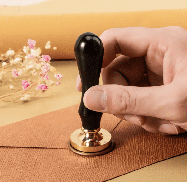 Hand applying a seal to an envelope.